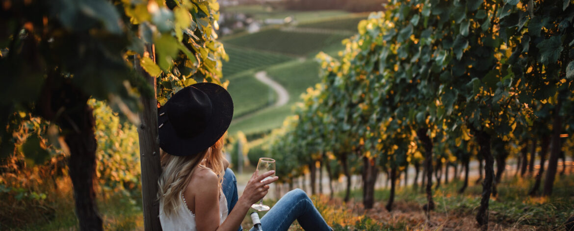 young-blonde-woman-relaxing-vineyards-summer-season-with-bottle-wine